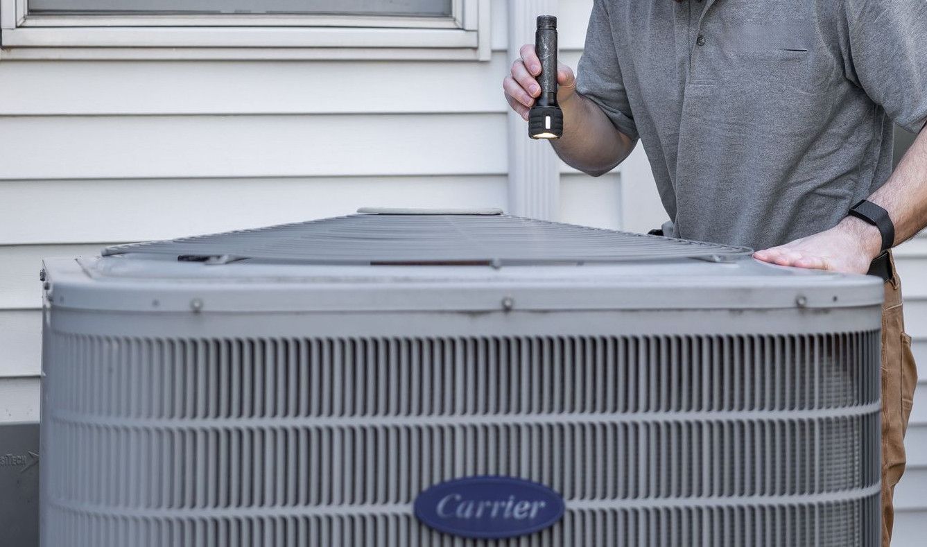 A technician inspects an outdoor HVAC unit for maintenance.