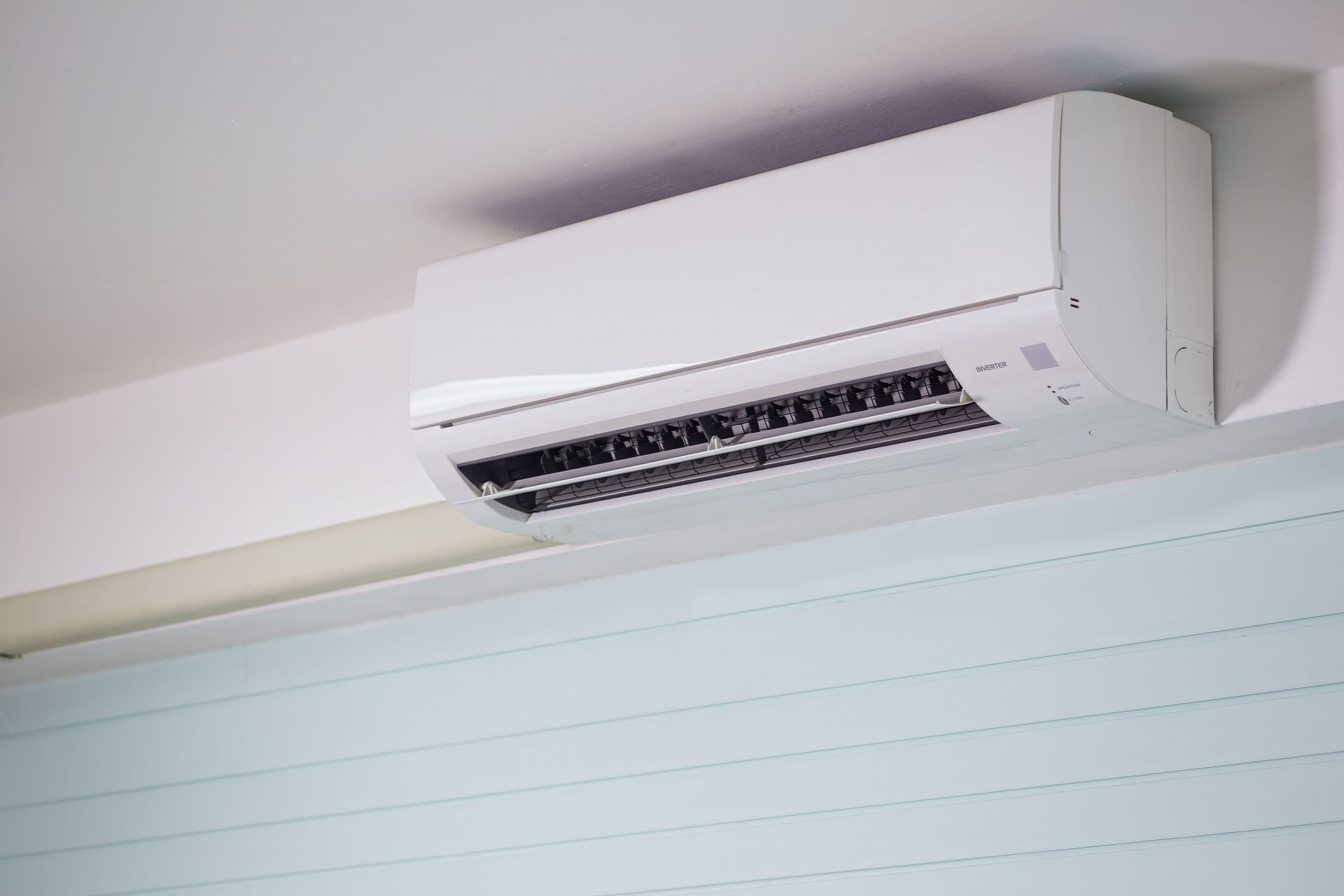 Close-up of a wall-mounted air conditioner indoors, showcasing sleek design for modern cooling solutions.